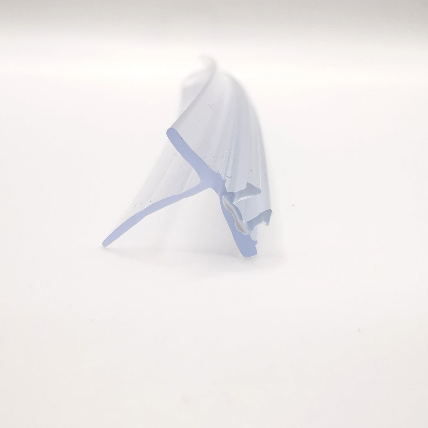 Nahaufnahme einer Ablaufleiste der Marke HÜPPE, transparentes, schmales, längliches, U-förmiges Kunststoffprofil, mit einem Ablaufschutz an der Profilunterseite, vor weißem Hintergrund.