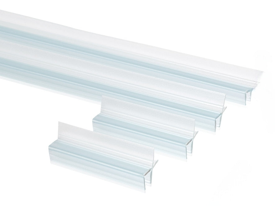 Nahaufnahme von vier Ablaufprofilen der Marke HÜPPE, transparente, schmale, längliche, U-förmige Kunststoffprofile, mit einem Ablaufschutz an der Profilaußenkante, in zwei Längen, vor weißem Hintergrund