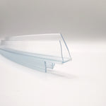 Detailaufnahme eines Ablaufprofils der Marke HÜPPE, transparentes, schmales, längliches, U-förmiges Kunststoffprofil, mit einem Ablaufschutz an den Profilaußenkante, vor weißem Hintergrund