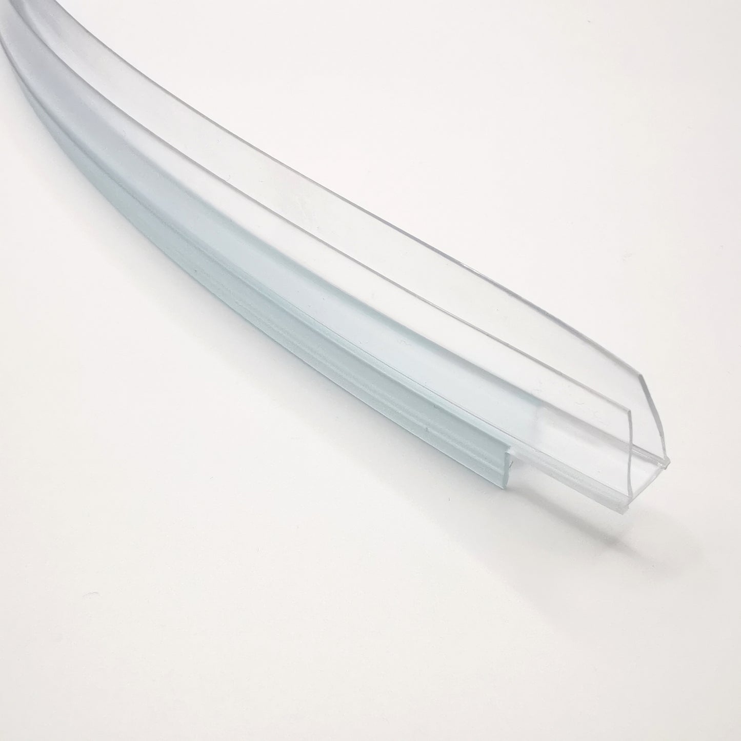 Nahaufnahme eines Ablaufprofils der Marke HÜPPE, transparentes, schmales, längliches, U-förmiges Kunststoffprofil, mit einem Ablaufschutz an den Profilaußenkante, vor weißem Hintergrund