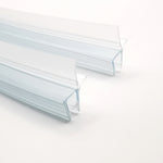 Detailaufnahme Ablaufprofil-Set der Marke HÜPPE bestehend zwei gebogenen, transparenten, schmalen, länglichen, U-förmigen Kunststoffprofil, mit einem Ablaufschutz an der Profilunterseite, vor weißem Hintergrund.