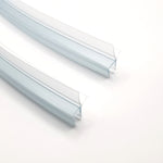 Nahaufnahme Ablaufprofil-Set der Marke HÜPPE bestehend zwei gebogenen, transparenten, schmalen, länglichen, U-förmigen Kunststoffprofil, mit einem Ablaufschutz an der Profilunterseite, vor weißem Hintergrund.