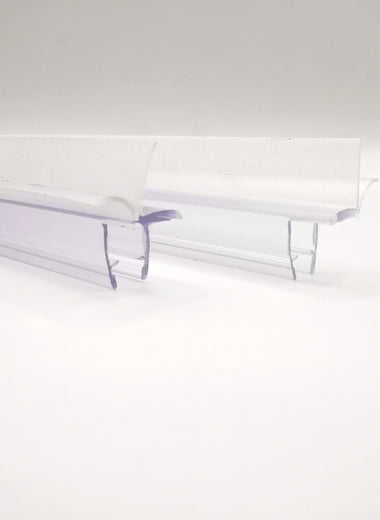 Nahaufnahme von zwei Ablaufprofilen der Marke HÜPPE, transparente, schmale, längliche, U-förmige Kunststoffprofile, mit einem Ablaufschutz an der Profilaußenkante, vor weißem Hintergrund, Seitenansicht.