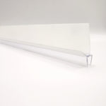 Nahaufnahme einer Ablaufleiste der Marke HÜPPE, transparentes, schmales, längliches, U-förmiges Kunststoffprofil, mit einem Ablaufschutz an den Profilaußenkanten, vor weißem Hintergrund.