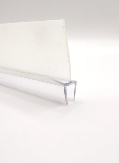 Detailaufnahme einer Ablaufleiste der Marke HÜPPE, transparentes, schmales, längliches, U-förmiges Kunststoffprofil, mit einem Ablaufschutz an den Profilaußenkanten, vor weißem Hintergrund.