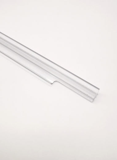 Nahaufnahme einer Dichtleiste der Marke HÜPPE, transparentes, schmales, längliches, U-förmiges, Kunststoffprofil, mit einem Ablaufschutz an der Profilvorderseite, vor hellem Hintergrund, Seitenansicht links.