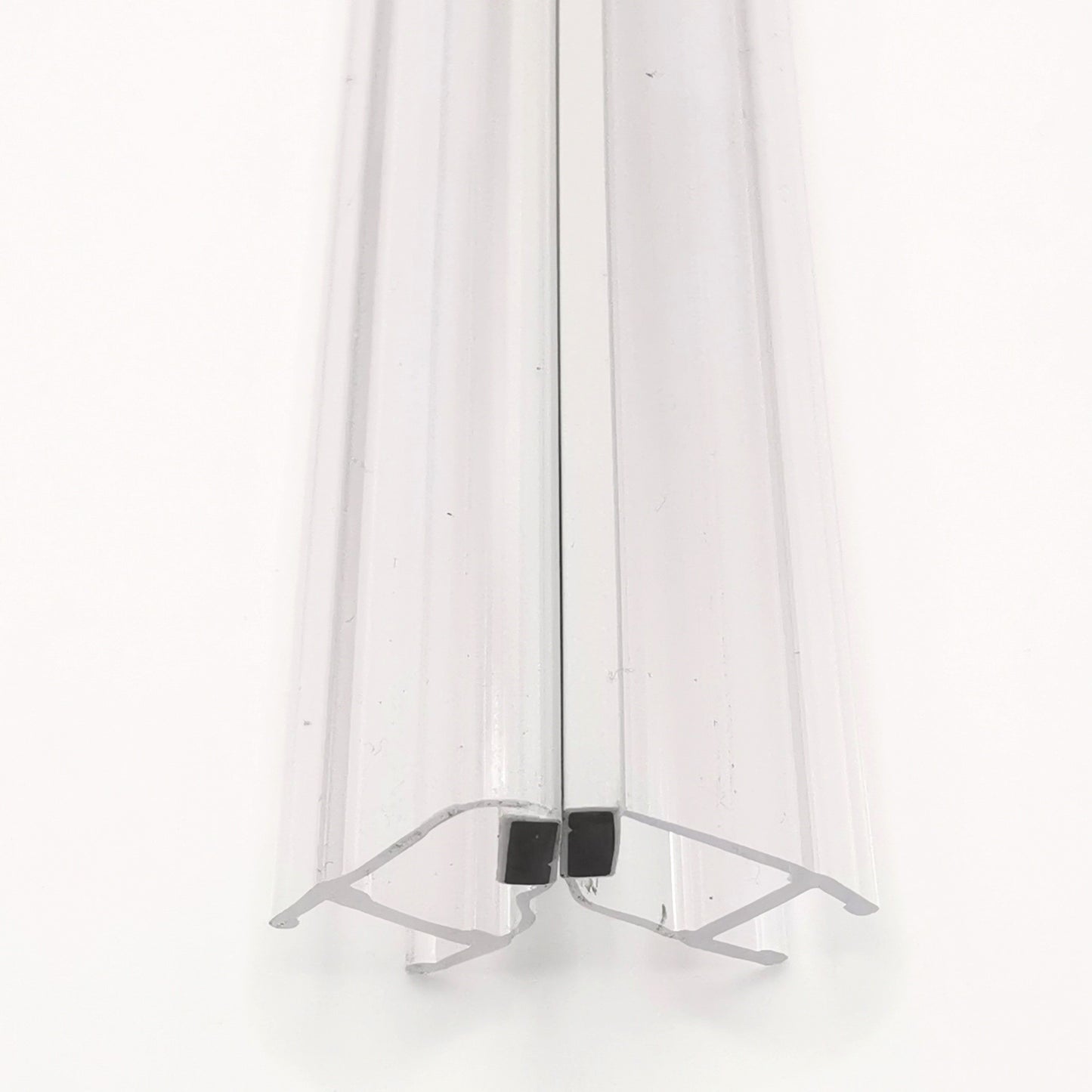 Nahaufnahme von zwei Magnetleisten der Marke HÜPPE, transparente, schmale, längliche, U-förmige Kunststoffprofile, mit je einem Magnetprofil an der Vorderseite, Magneten bilden zusammen geschlossenen 90 Grad Winkel, vor weißem Hintergrund.
