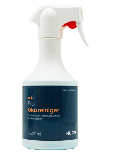 Sprühflasche des Glasreinigers ‚Flip Glasreiniger‘ von HÜPPE mit weißem Sprühkopf und dunkelblauem Etikett, auf dem Produktinformationen auf Deutsch stehen. Die Flasche hat ein Fassungsvermögen von 500 ml und ist ‚Made in Germany