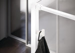 Select+ Hook, Weißer, matter Haken der Marke HÜPPE, der an einem senkrechten Profil einer Glasdusche montiert ist, daran hängt ein graues Handtuch, in einem modernen Badezimmer mit dunkelbraunem Fußboden.