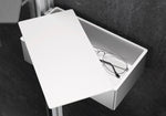 Silberne Select+ Box der Marke HÜPPE befestigt an einer Wandleiste einer Glasdusche, mit weißem, offenstehendem Deckel, darin liegt eine Brille, vor einer dunklen, strukturierten Wand.