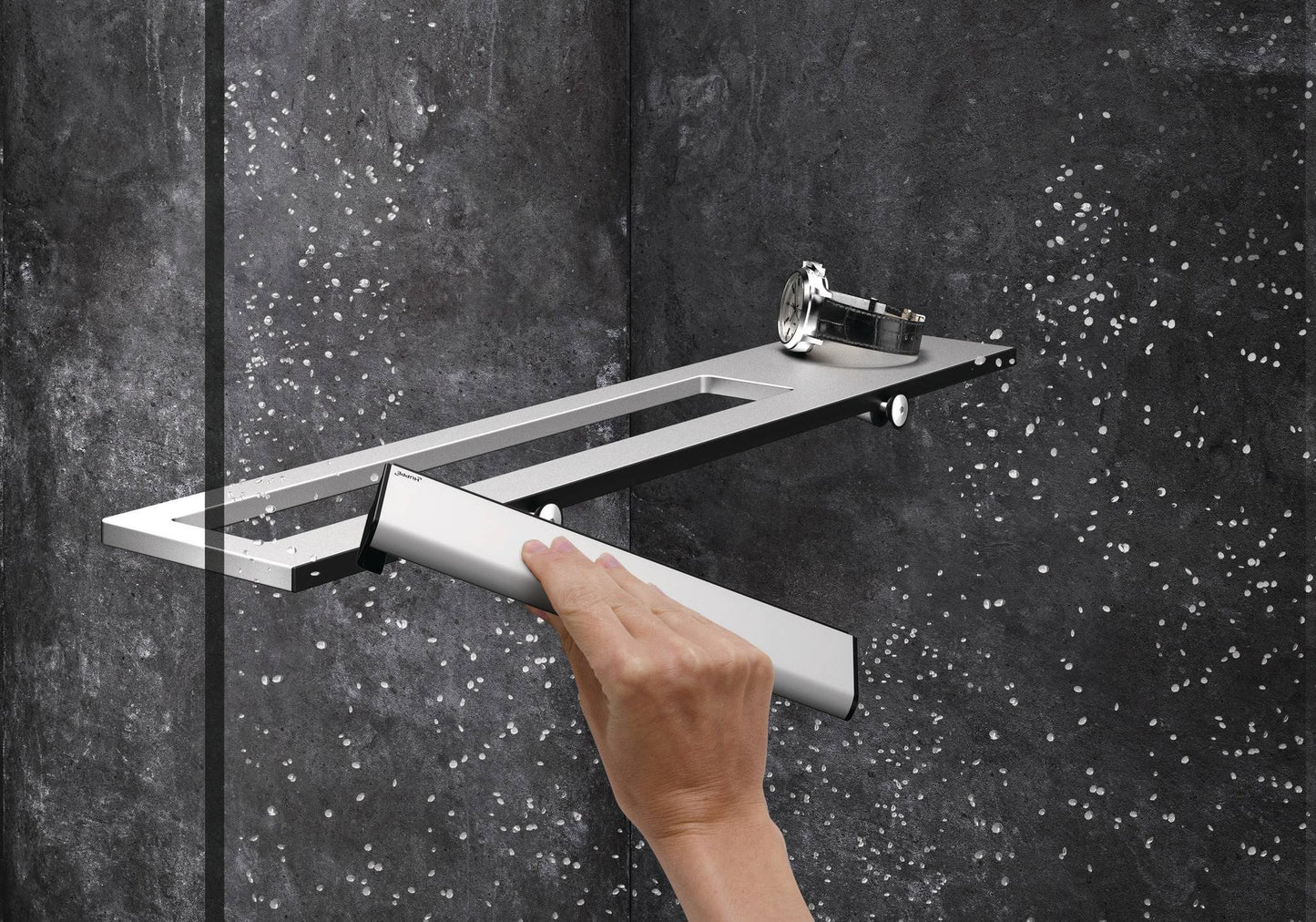 Hand wischt Wassertropfen von einer Glasdusche mit dem HÜPPE Select+ Wiper in silber, während eine Uhr auf einer modernen Ablage vor einer dunklen, strukturierten Wand liegt.