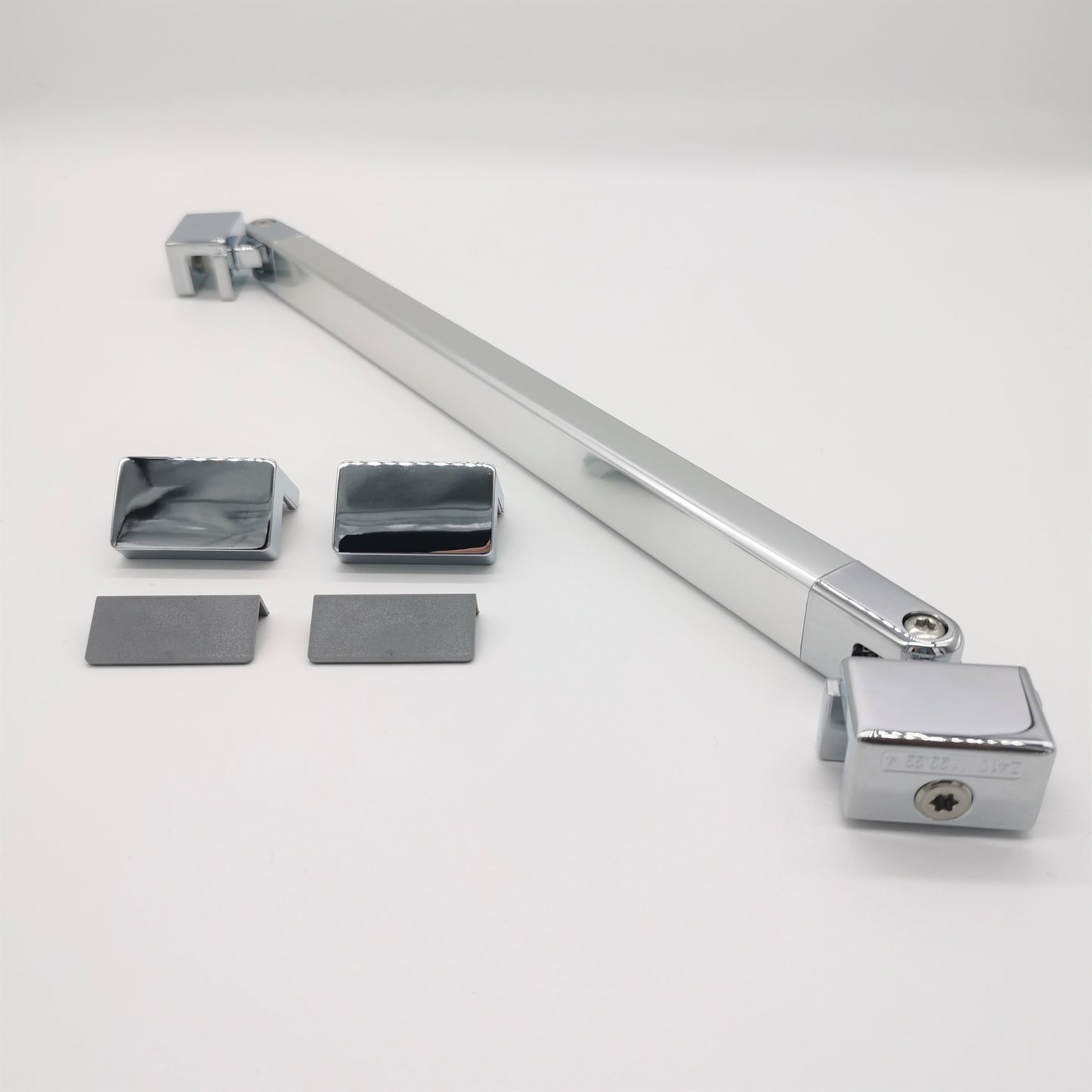 Stabilisierungsbügel-Set der Marke HÜPPE, bestehend aus einem schmalen Silber hochglänzenden Stabilisierungsbügel, zwei Abdeckkappen sowie zwei hellgraue Kunststoffwinkel, vor weißem Hintergrund, Seitenansicht.