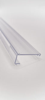 Detailaufnahme einer Glasklemmleiste der Marke HÜPPE, transparentes, schmales, längliches, Kunststoffprofil, mit einem L-förmigen Querschnitt, vor weißem Hintergrund, Seitenansicht.