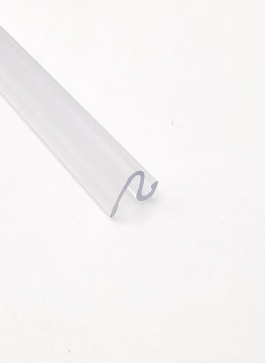 Dichtleiste der Marke HÜPPE, transparentes, schmales, längliches Kunststoffprofil, im Querschnitt S-förmig, vor weißem Hintergrund, Seitenansicht.

