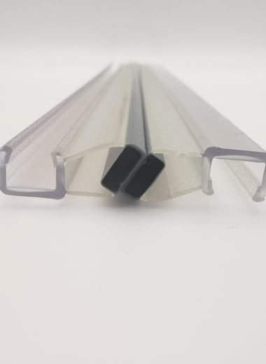 Detailaufnahme von zwei Magnetdichtung der Marke HÜPPE, transparente, schmale, längliche, U-förmige Kunststoffprofil, mit einem Magnetprofil an der Außenseite, 45 Grad abgewinkelt, vor weißem Hintergrund, Frontansicht.
