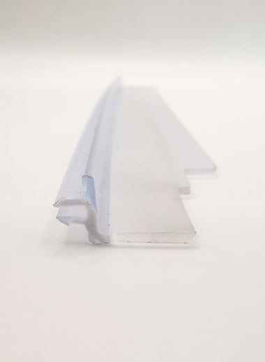 Dichtleiste der Marke HÜPPE, transparentes, schmales, längliches, L-förmiges Kunststoffprofil, mit zwei Lamellen an der linken Profilaußenseite, vor weißem Hintergrund, Frontansicht.
