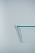 Nahaufnahme einer Magnetleiste der Marke HÜPPE, transparentes, schmales, längliches, U-förmiges Kunststoffprofil, mit einer Magnetleiste an der Profilvorderseite, montiert an Glasdusche, vor weißem Hintergrund, Seitenansicht rechts.