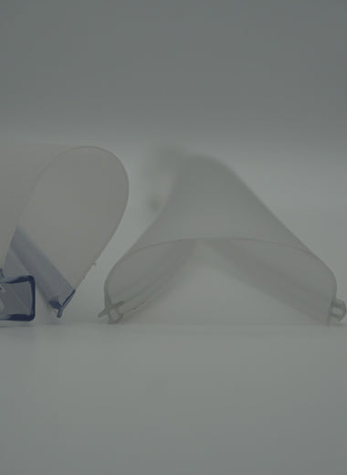 Nahaufnahme eines Dichtprofils der Marke HÜPPE, transparentes, schmales, längliches, U-förmiges Kunststoffprofil, durch ein transparentes, flexibles, zum Bogen geformtes Zwischenelement, mit einem T-förmigen Kunststoffprofil verbunden sowie eine weitere transparente und flexible Kunststoffbahn, vor hellem Hintergrund.
