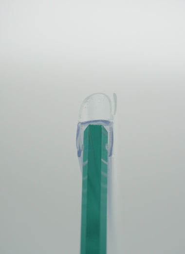Nahaufnahme eines O-Profils der Marke HÜPPE, transparentes, schmales, längliches, U-förmiges Kunststoffprofil, mit einem O-förmigen Profil an der Profilvorderseite, montiert an Glasdusche, vor weißem Hintergrund.
